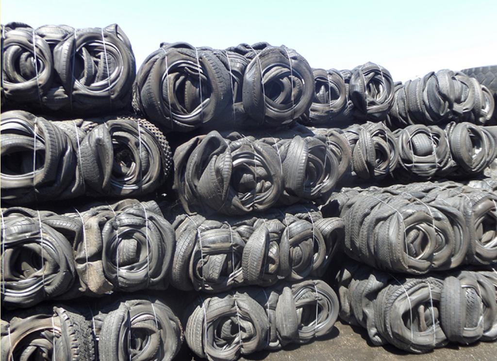 Baled scrap tyres strapped and stacked, ready for container loading